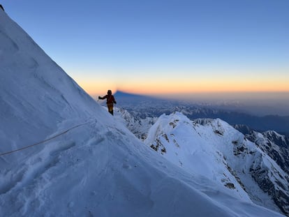 Benjamin Védrines, al amanecer en la ruta Schell del Nanga Parbat, cuya sombra se proyecta a sus espaldas.