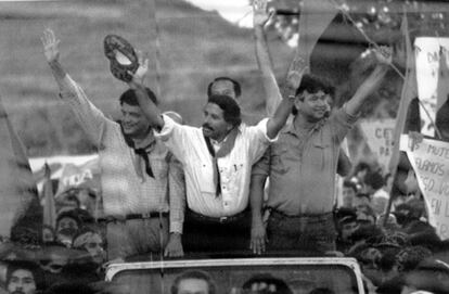 El presidente de Nicaragua, Daniel Ortega (centro), saluda a sus seguidores desde un coche descubierto, en al ciudad de Masaya durante la campaña para su reelección, flanqueado por el vicepresidente Sergio Ramírez (izquierda) y el candidato para la Asamblea Nacional William Ramírez, en 1989.