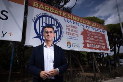 Miguel Molina, alcalde de Barbate, junto a un cartel de gastos en bases militares, el miércoles.