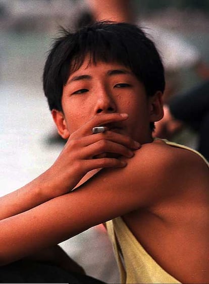 Un niño de 12 años fumando en una calle de Pekín.