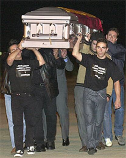 Compañeros del cámara de Tele 5 portan el féretro a su llegada a Madrid.