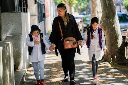 Una mujer lleva a sus hijos a la escuela en Montevideo, en noviembre de 2020