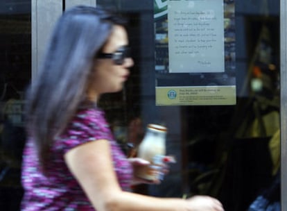 Una mujer pasa frente a una tienda de Starbucks de Nueva York que luce un letrero de cierre
