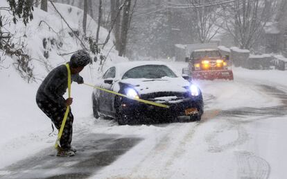 Un hombre ayuda a un conductor a sacar su coche de la nieve en Irvington, en el estado de Nueva Jersey (EE UU).