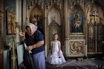 En Rumanía, viven algo más de 620 000 romaníes. En la imagen, una niña espera a su madre, después de pasar por el altar de una iglesia de Costesti (Rumanía).