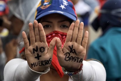 Una mujer muestra un mensaje escrito en las palmas de sus manos durante una manifestación denominada 'Venezuela le da un mensaje a la FAN (Fuerza Armada)', el 24 de junio de 2017, en Caracas (Venezuela).
