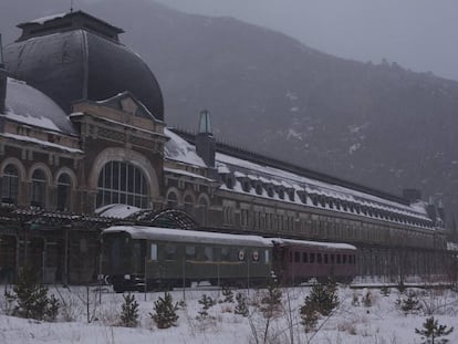 Vista exterior de la estación de Canfranc con dos vagones restaurados.