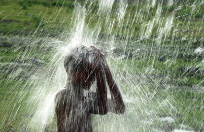 Un niño utiliza un grifo de la calle para refrescarse en medio del aumento de las temperaturas en la India.