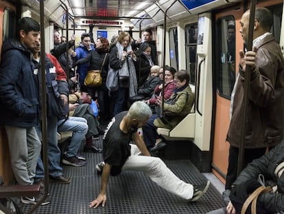 Una persona baila en un coche del metro de Madrid.
