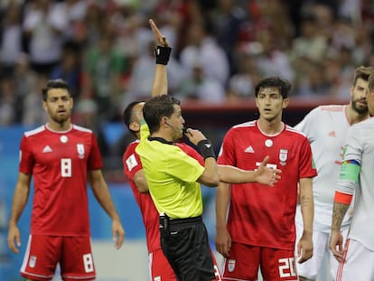 Los jugadores de Irán y de España esperan la resolución del VAR sobre un posible gol.