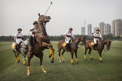 El jugador chino Lin Yongye, segundo por la izquierda, intenta controlar su caballo mientras él y sus compañeros de equipo abandonan el campo después de un partido de exhibición contra los Estados Unidos y Gran Bretaña, en el club de polo Goldin Metropolitan de Tianjin, China.