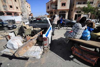 Varios gazatíes observan a miembros de Hamás retirar en una camioneta munición que no ha estallado en los bombardeos, en Yan Junis, el 24 de noviembre, primer día de tregua. 