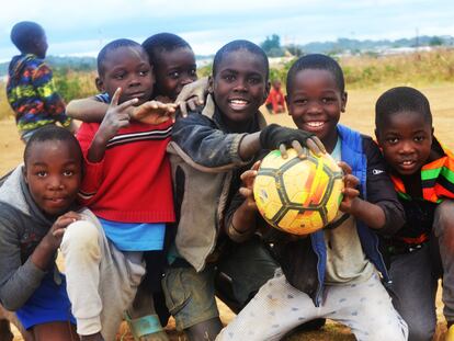 Un grupo de niños posa con un balón en el campo de fútbol de Bauleni, Lusaka.