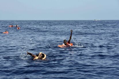 Diverses persones esperen que algú els rescati al mar Mediterrani, a 12 milles nàutiques de la costa de Líbia, el 4 d'octubre.