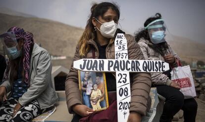 Ruth Morales, de 36 años, espera a la llegada del ataúd de su marido, Juan Paucar Quispe, de 63 y fallecido por complicaciones derivadas de la covid-19, en el cementerio de Carabayllo de Lima (Perú) el 25 de agosto de 2020.