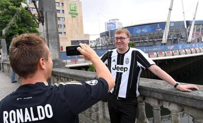 Aficionados de la Juventus y del Real Madrid posan ante el estadio Cardiff City en la víspera de la final de la Liga de Campeones.