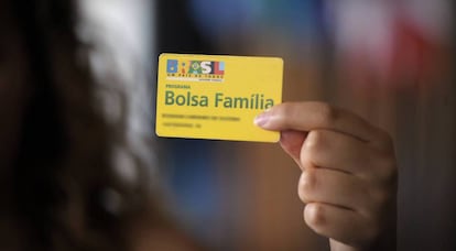 Beneficiária do programa de transferência de renda do Governo segura um cartão do Bolsa Família. 