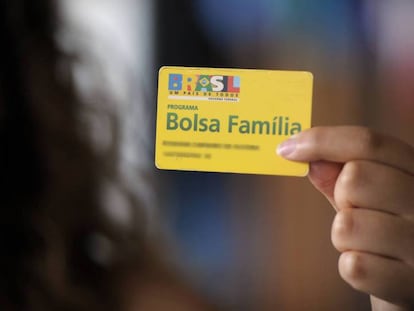 Beneficiária do programa de transferência de renda do Governo segura um cartão do Bolsa Família. 