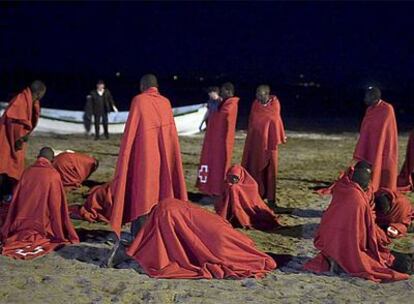 Un grupo de inmigrantes se recupera en una playa de Tenerife de la travesía en patera el pasado febrero.
