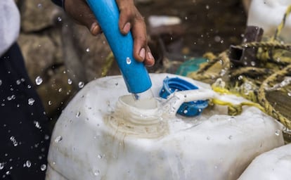 Un habitante de Ciudad de México llena un contenedor de agua.