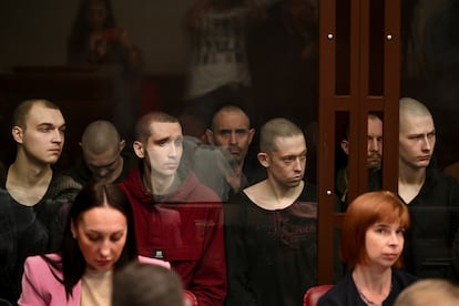 Ukrainian soldiers who were taken prisoner during fighting sit inside a defendant's glass cage during a hearing at the Southern District Military Court in Rostov-on-Don, Russia,, 2023