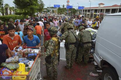 Soldados comprueban los carros de personas procedentes de un centro comercial en Acapulco. El famoso balneario de Acapulco, México era un caos el martes los hoteles racionaban alimentos para miles de turistas varados.