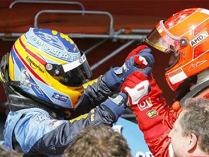 Fernando Alonso da la enhorabuena a Michael Schumacher por su triunfo.