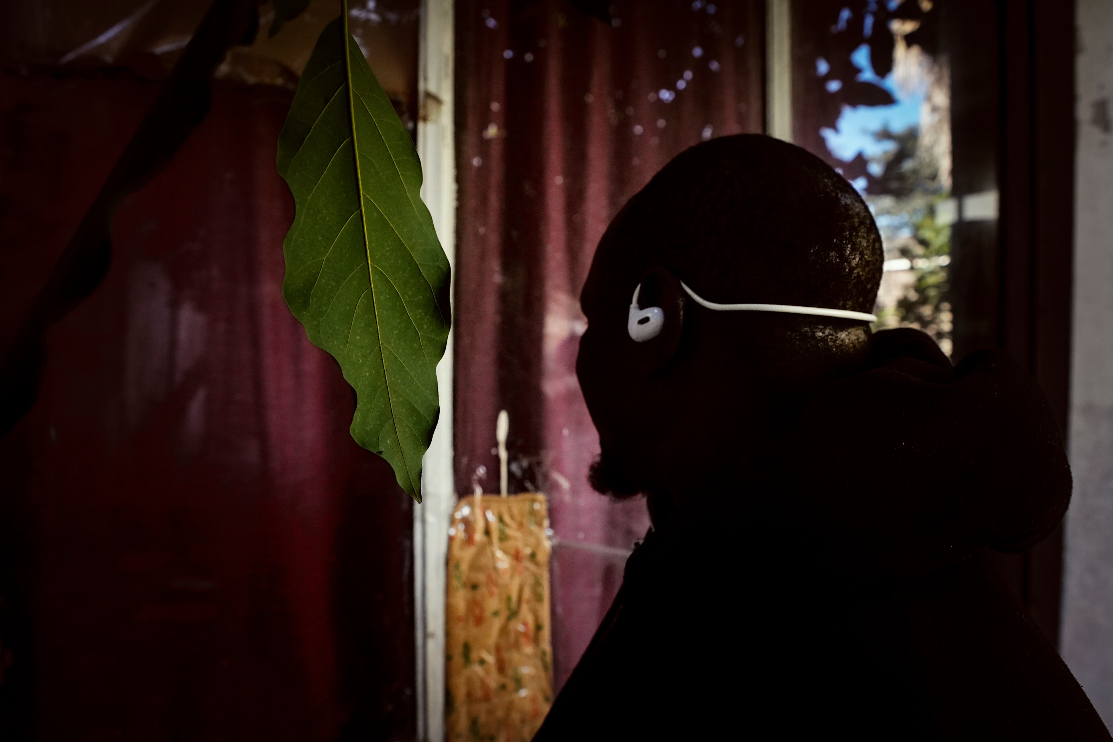 Un vendedor ambulante senegalés posa protegiendo su identidad, tras ser abordado por personal policial, de migraciones, en el barrio de Flores, Buenos Aires.