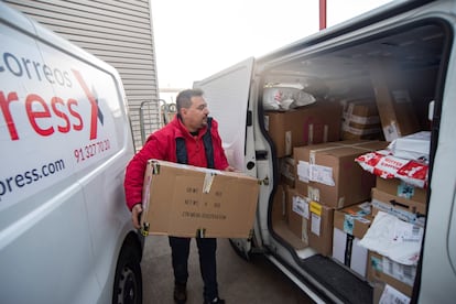 Trabajadores de Correos Expres, empresa de transportes cargando sus furgonetas antes de salir a repartir en una nave del Poligono Industrial de Mahón, Menorca.