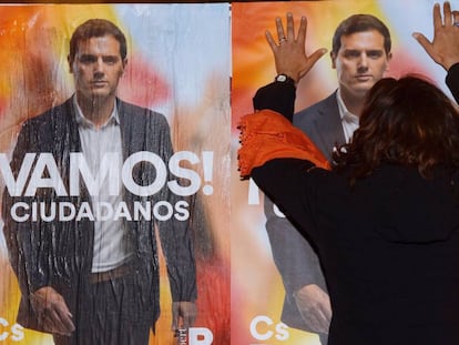 Una simpatizante de Ciudadanos pega un cartel del candidato de su partido a la presidencia del Gobierno, Albert Rivera, durante el unicio de la campaña electoral en Valladolid. 