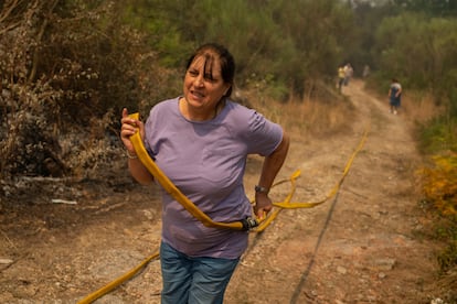 Una mujer colabora este sábado en las labores de extinción de un incendio en Carballeda de Avia (Ourense).