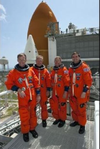 Los cuatro astronautas que volarán en la última misión de un transbordador posan junto al <i>Atlantis</i> en la parte superior de estructura de la plataforma de lanzamiento.