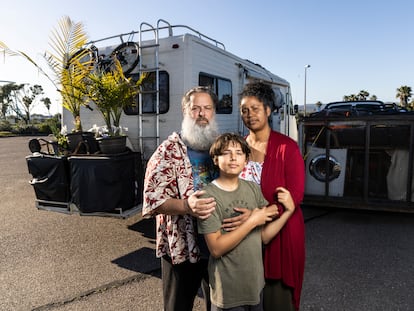 Chris and Julienna Endres with their son Ayden in front of their motorhome in a San Diego (California) parking lot.