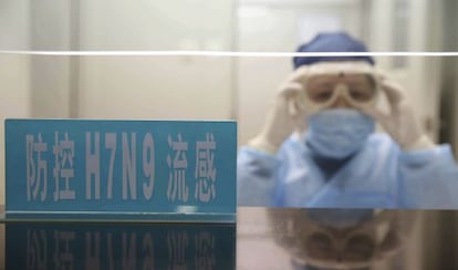 Un trabajador del hospital se ajusta las gafas en el mostrador para los casos de la nueva cepa H7N9 en Shanghái.