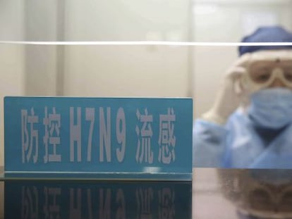 Un trabajador del hospital se ajusta las gafas en el mostrador para los casos de la nueva cepa H7N9 en Shanghái.