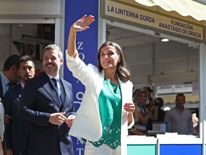 La reina Letizia saluda a los visitantes de la Feria del Libro de Madrid, durante su paseo inaugural este viernes.