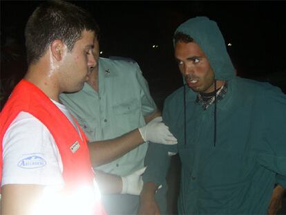 Un miembro de Cruz Roja atiende a uno de los inmigrantes localizados cerca de Motril.
