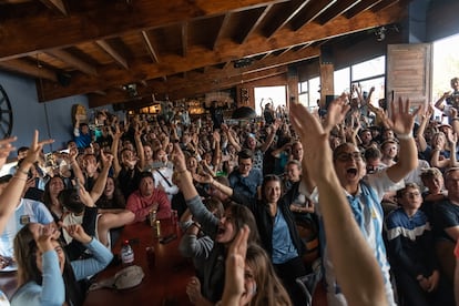 Turistas argentinos y franceses miran la final del mundial de fútbol de 2022 en una bar de El Chaltén.
