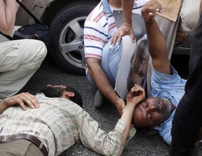 Dos heridos en el suelo durante los enfrentamientos del ejercito egipcio con los partidarios de los Hermanos Musulmanes en los alrededores de la sede de la Guardia Republicana, 5 de julio de 2013.