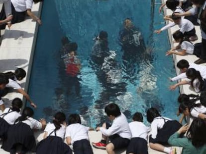 Un grupo de escolares observa la instalación 'La pileta', de Leandro Erlich, mientras otros visitantes la recorren por dentro. 