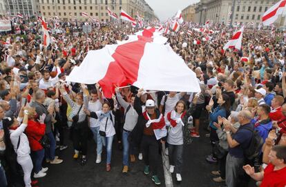 Los manifestantes ondean la bandera histórica de Bielorrusia, durante la manifestación de esta tarde.