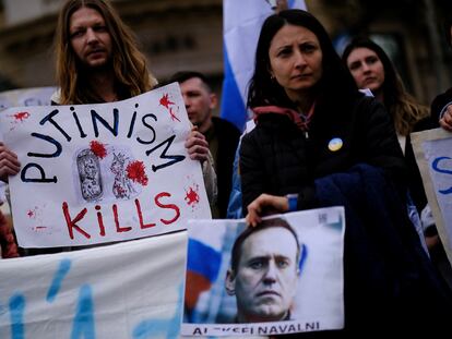 People hold a banner and a image of late Russian opposition leader Alexei Navalny on his memorial at Las Ramblas of Barcelona, Spain, February 25, 2024.