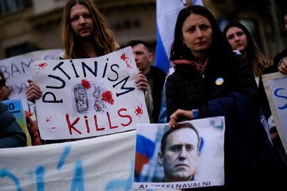 People hold a banner and a image of late Russian opposition leader Alexei Navalny on his memorial at Las Ramblas of Barcelona, Spain, February 25, 2024.