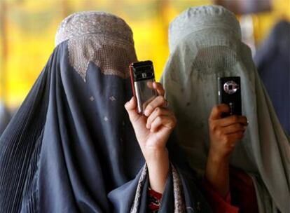 Dos mujeres ataviadas con el <i>burka</i> hacen fotos con sus móviles durante un mitin de Hamid Karzai en Kandahar.
Mujeres afganas se disponen a votar el 20 de agosto pasado.