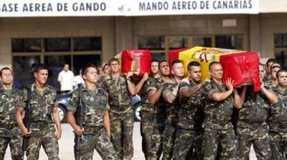 Varios soldados transportan los féretros de los dos militares fallecidos en Afganistán a su llegada al aeropuerto de Gando (Gran Canaria) ayer por la tarde.