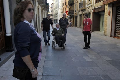 La escolta de Elola (al fondo, primero por la izquierda) vigila mientras el edil pasea con su familia.