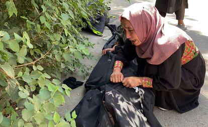 Una mujer llora junto al cadáver de una víctima de la explosión de una bomba en el aeropuerto, en un hospital de Kabul, este domingo.