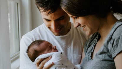 Dos padres miran a su recién nacido. 