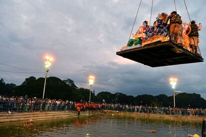 Voluntarios transportan ídolos hindúes sobre una plataforma para su posterior inmersión en el agua durante el festival de Ganesh Chaturthi en Bangalore (India).