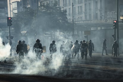 Agentes de policía caminan entre el humo de las barricadas levantadas por los estudiantes del movimiento 'Bloqueemos todo' en Paris.